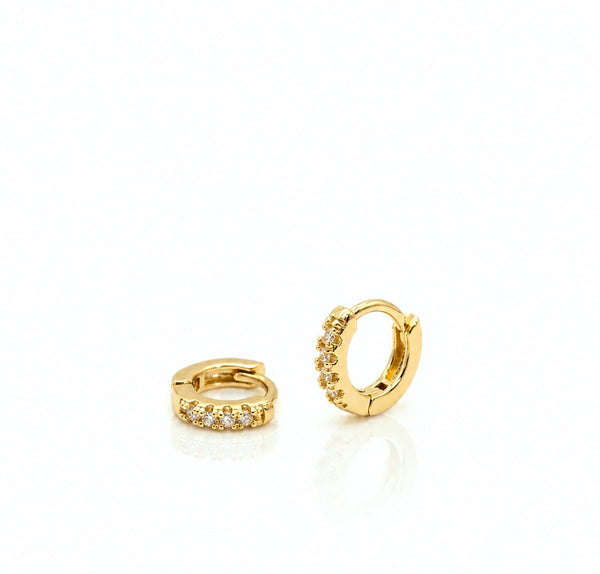 Two gold hoop earrings with embedded stones on a white background