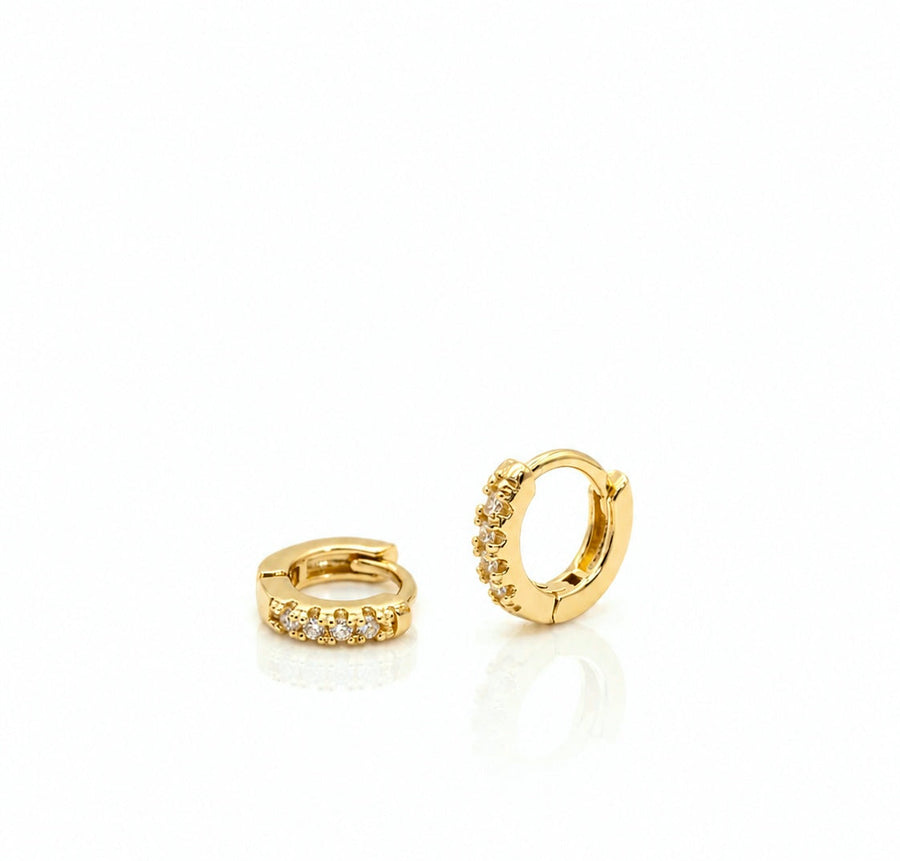 Two gold hoop earrings with embedded stones on a white background